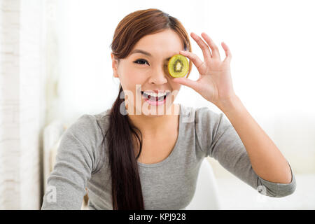 Young woman showing slices of kiwi fruit Stock Photo