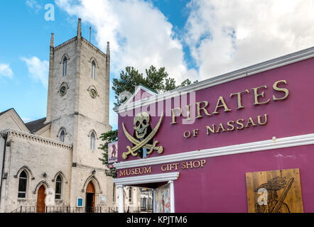 Exterior of the Pirates of Nassau museum beside Christ Church Cathedral with its bell tower in downtown Nassau, the Bahamas. Stock Photo