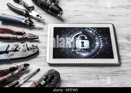 Tablet pc with security concept on screen and industrial tools around Stock Photo