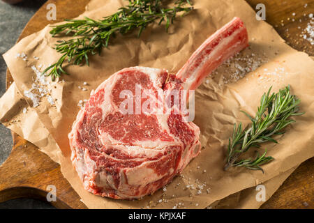 Raw Red Grass Fed Tomahawk Steaks with Rosemary Stock Photo