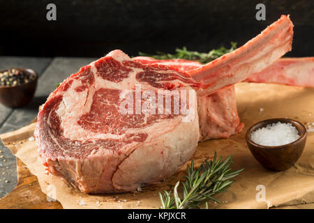 Raw Red Grass Fed Tomahawk Steaks with Rosemary Stock Photo