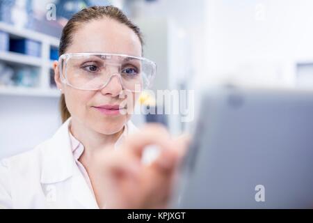 Female laboratory assistant using tablet. Stock Photo
