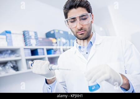 Male laboratory assistant using pipette. Stock Photo