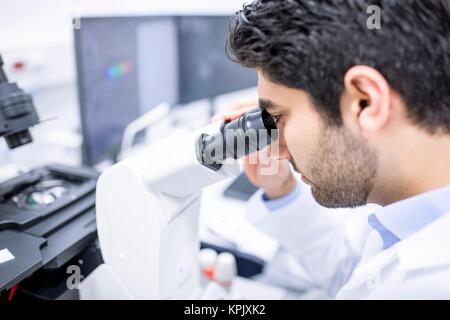 Male scientist using microscope, close up. Stock Photo