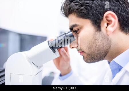 Male scientist using microscope, close up. Stock Photo