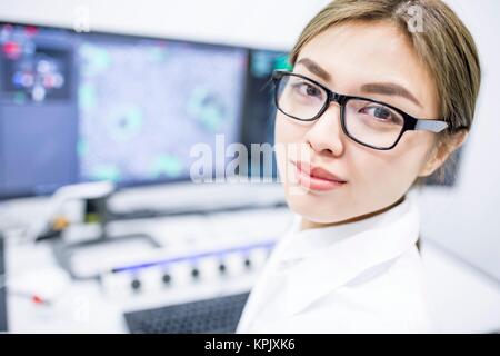Female scientist wearing glasses, looking at camera. Stock Photo