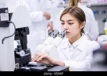 Female scientist using microscope in laboratory. Stock Photo
