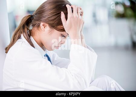 Young female medical student with head in hands. Stock Photo