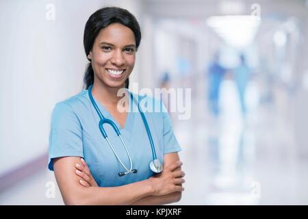 Female doctor smiling towards camera with arms folded. Stock Photo