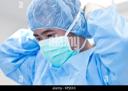 Surgeon putting on surgical mask Stock Photo - Alamy