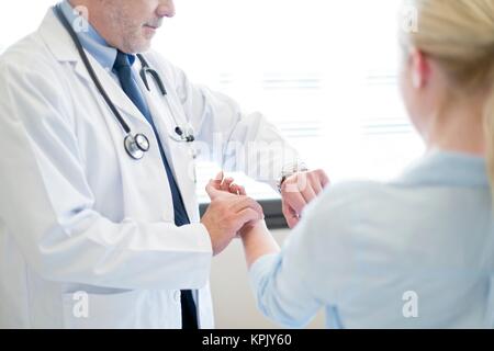 Male doctor taking patient's pulse. Stock Photo