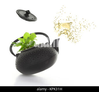 Teapot with green herbs and tea splash isolated Stock Photo