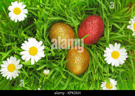 Easter background with grass, flowers and colorful glitter eggs Stock Photo