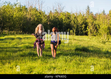 Two friends hiking and talking in a park; Edmonton, Alberta, Canada Stock Photo