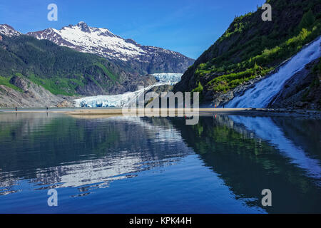 Tourists viewing Mendenhall Glacier and Nugget Falls in Mendenhall Park Recreation Area, near Juneau; Alaska, United States of America Stock Photo