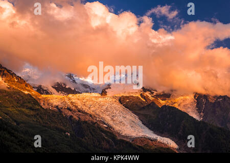 Clouds over Mont Blanc and Bossons Glacier glowing at sunset, Alps; Chamonix-Mont-Blanc, Haute-Savoie, France Stock Photo