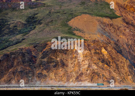 A bus stirs up dust along the park road in Denali National Park while passing underneath a group of Dall sheep (ovis dalli) near the base of Polych... Stock Photo