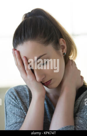 Sad young woman covering eye with hand in regret Stock Photo