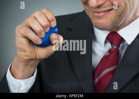 Businessman Pressing Stressball In Hand Stock Photo