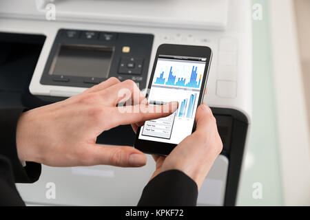 Businesswoman Giving Print Command On Smart Phone Stock Photo