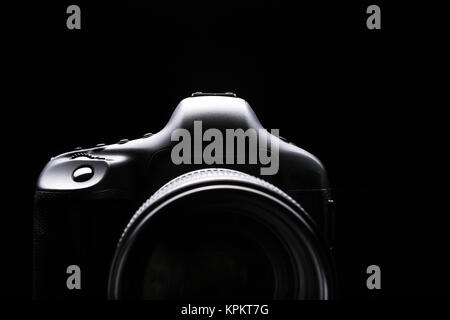 Professional modern DSLR camera low key image - Modern DSLR camera with a very wide aperture lens on Stock Photo