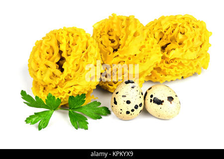 Curly fettuccine pasta and quail eggs. Stock Photo