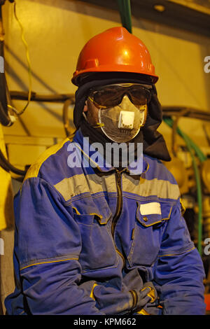 The worker in overalls and a respirator Stock Photo