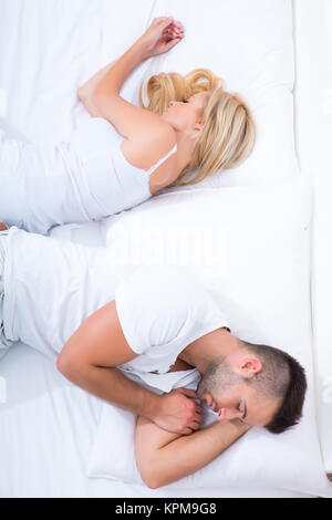 Young couple turning the back to each other in Bed. Stock Photo