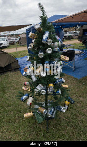 Small green artificial Christmas tree decorated with empty blue, gold, blue and white beer and cider cans at Meredith Music Festival. Stock Photo