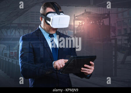Serious man with virtual reality goggles using touchpad Stock Photo