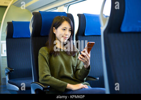 Woman use of cellphone inside train compartment Stock Photo