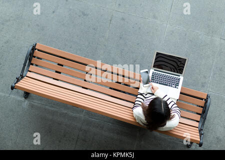 Woman use of laptop computer with checking text message on cellphone Stock Photo