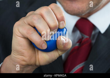 Businessperson Pressing Stressball In Hand Stock Photo