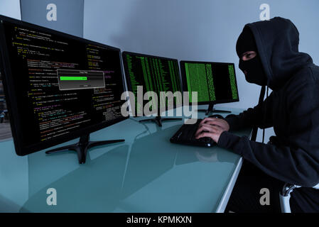 Hacker Stealing Data On Multiple Computers Stock Photo