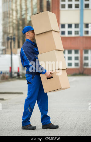 Delivery Man Balancing Stack Of Boxes Stock Photo