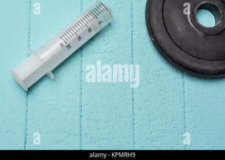 Injection and disc from dumbbell. Close-up. Blue background Stock Photo