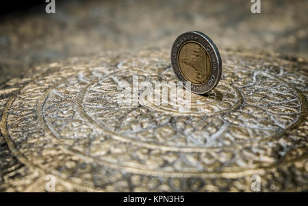 Thai 10-Baht Coin on a Plate in Buddhist Temple Stock Photo