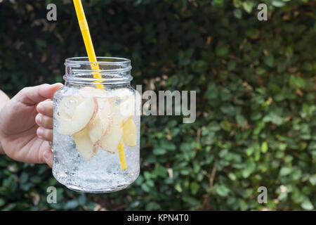 Hand hold glass of iced apple soda drink Stock Photo