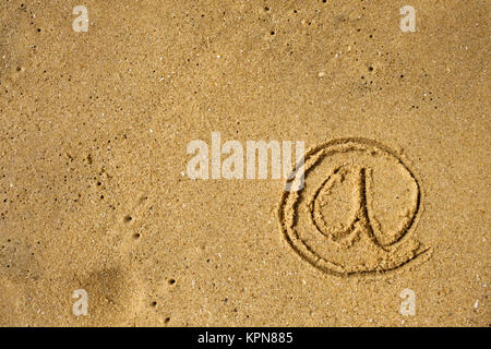 Mail Icon drawn on sea shore sand. Stock Photo