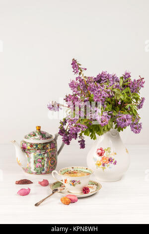 Tea with  lemon and bouquet of  lilac primroses on the table Stock Photo