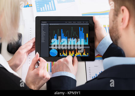 Two Businesspeople Analyzing Graph On Digital Tablet Stock Photo