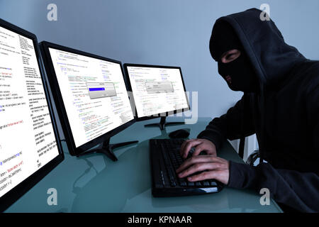 Hacker Stealing Data On Multiple Computers Stock Photo