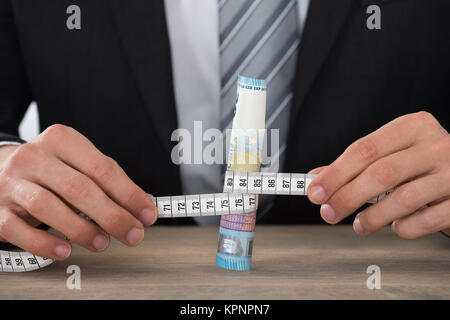 Businessman Hand Measuring Bank Note Stock Photo