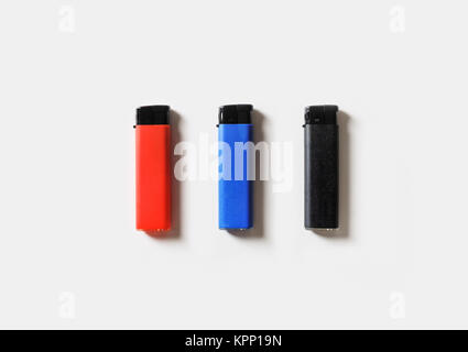 Blank plastic gas lighters on white paper background. Flat lay. Stock Photo