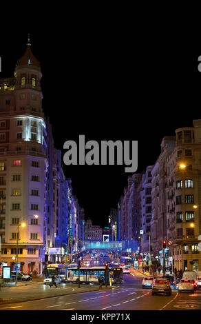 Madrid, Spain - December 11, 2017. Nightfall view of Gran Via street illuminated by christmas lights and neon signboards located in central Madrid. Vi Stock Photo