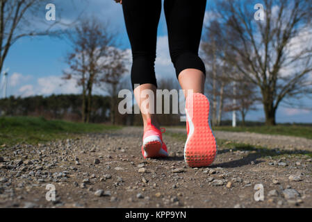 jogger running on a dirt road in the spring Stock Photo