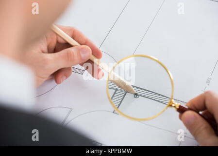 Architect Working With Magnifying Glass Stock Photo
