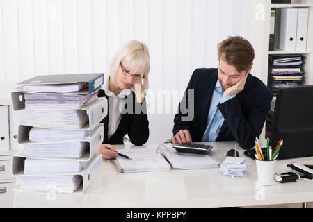 Businesspeople Calculating Invoices Stock Photo