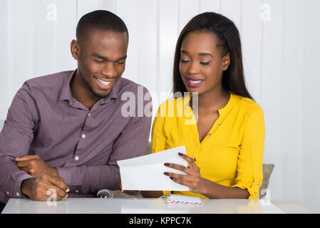 Happy Couple Reading Letter Stock Photo
