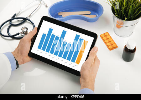 doctor analyzing healthcare stats report on digital tablet Stock Photo